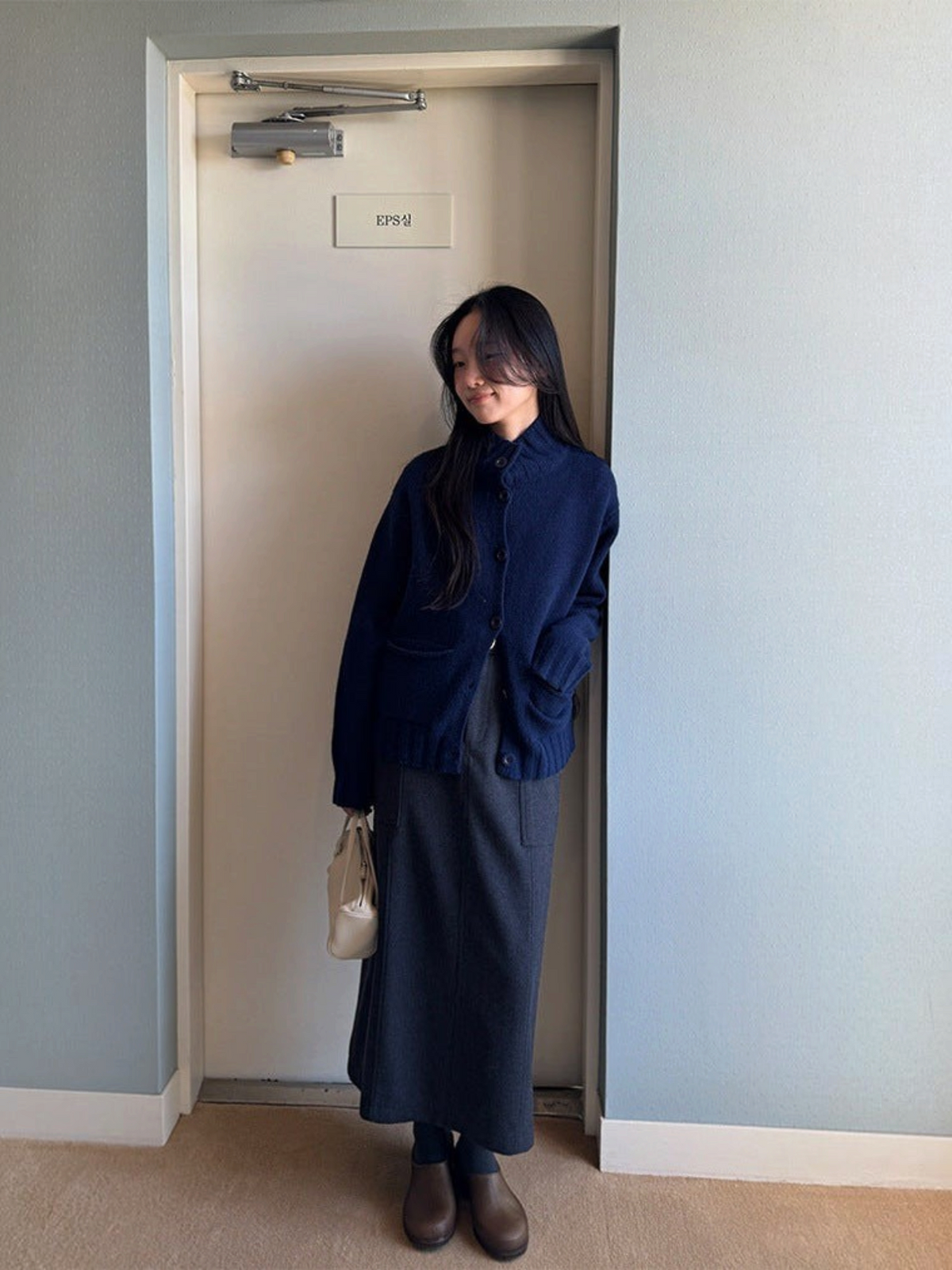 IROHI 模特身穿深蓝色羊毛开衫，搭配深灰色长裙，展现简约优雅的日常穿搭风格