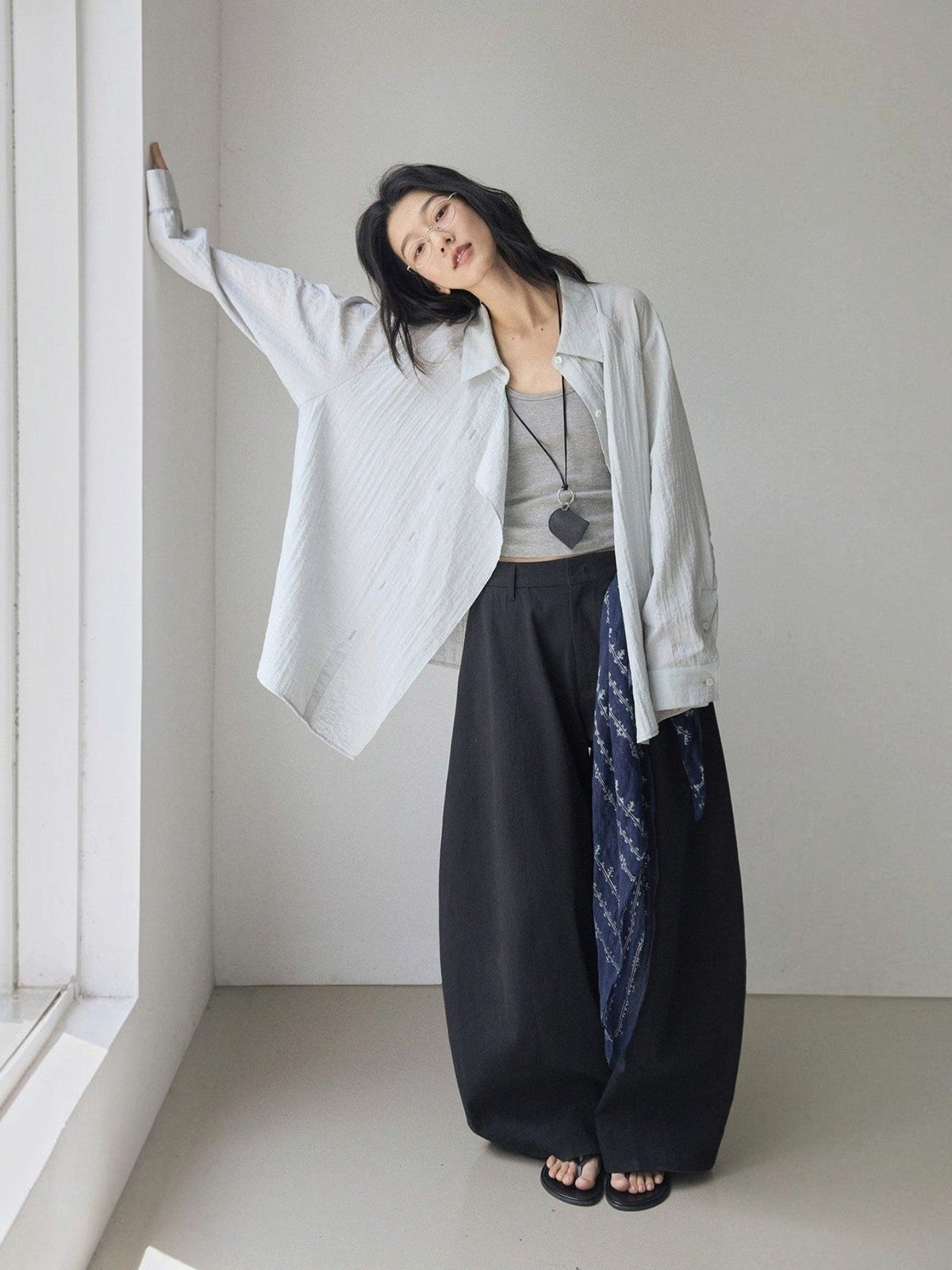 IROHI模特身穿黑色立体曲线剪裁长裤，搭配浅色宽松衬衫，展现简约休闲风格