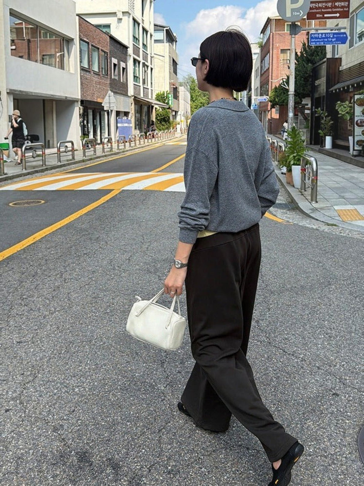 IROHI灰色羊毛混纺针织长袖Polo衫，模特在街道上行走，展现休闲优雅的秋季穿搭风格